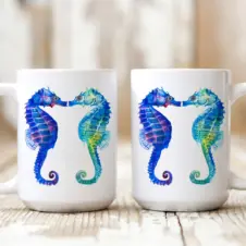 The Ship's Hold Watercolor Artwork 15oz Ceramic Mug, Kissing Seahorses (pair on table)